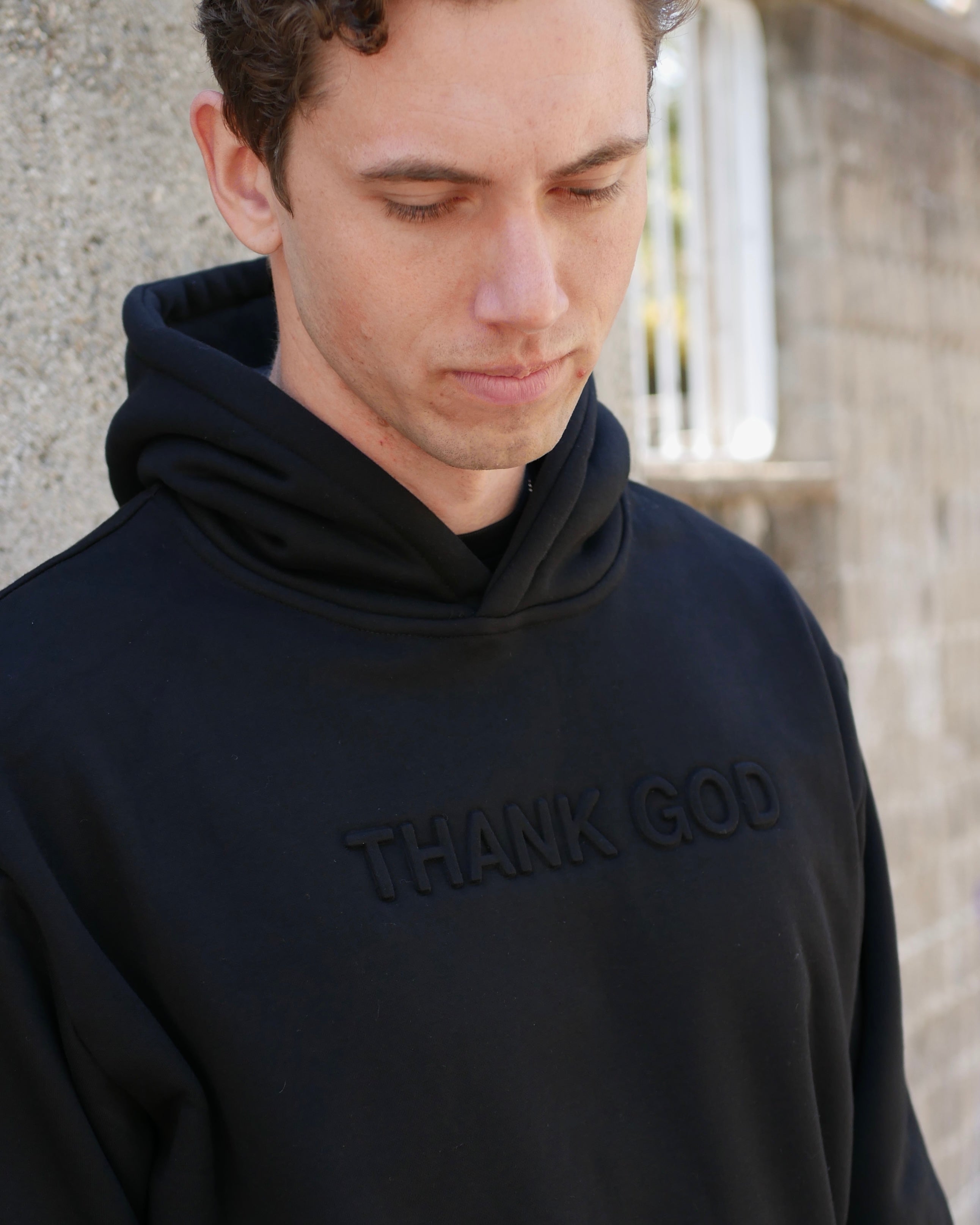 Faith-based Christian hoodie by Thank God with unique black EMBOSSED HOODIE design close up